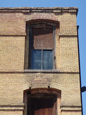 Photo of the brick arches before repair. Crack visable and sevferal bricks spalling.